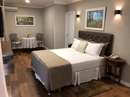 拉戈阿韦梅利亚Lagoa Parque Hotel的一间卧室配有一张床和一张桌子及椅子