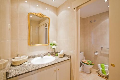 巴塞罗那埃伊桑普雷康福特公寓的一间带水槽、镜子和卫生间的浴室