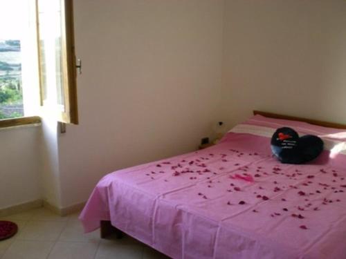 圣玛丽亚Apartment Da Mario的一只塞满鲜花的动物坐在粉红色的床上