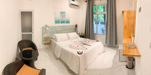 拉斯杜Fins Dive and Leisure Hotel的客厅配有白色的沙发和床。