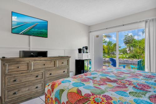 马拉松椰树沙洲度假村的一间卧室配有一张床和一台平面电视