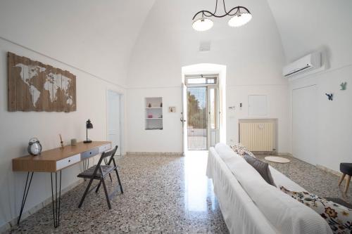 莫诺波利Porta Sugli Ulivi的白色的客厅配有沙发和书桌