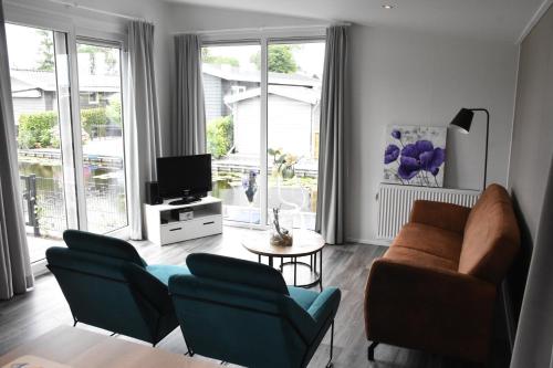 羊角村Chalet ‘Het Giethoornsche Meer’ (16)的客厅配有沙发、椅子和电视