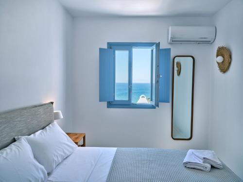 皮索利瓦迪Etherio Apartment III的一间卧室设有一张床和一个海景窗户