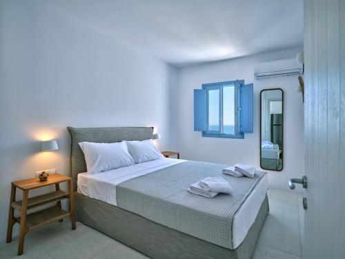 皮索利瓦迪Etherio Apartment III的白色卧室配有床和镜子