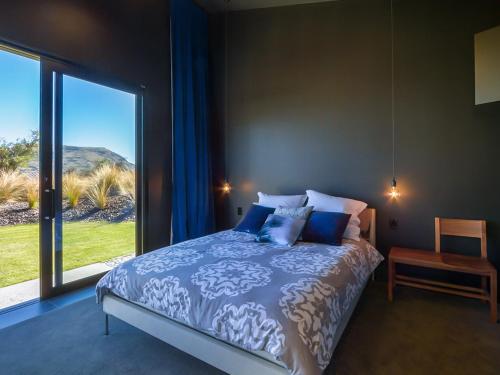 皇后镇Point Vista - Queenstown Luxury的一间卧室设有一张床和一个大窗户