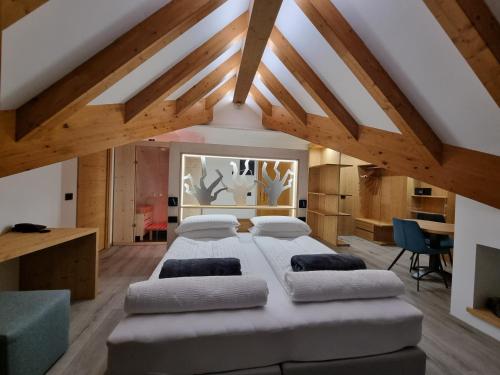 安达洛加拿大酒店 的一间带一张大床的卧室,位于一个拥有木制天花板的房间
