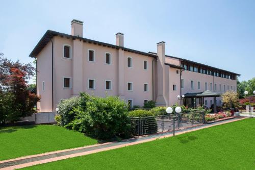 威尼托自由堡费耶餐厅酒店的前面有绿色草坪的大建筑