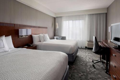 米尔福德波士顿米尔福德万怡酒店的酒店客房配有两张床和一张书桌
