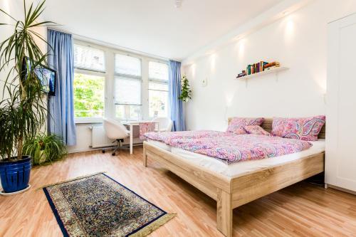 科隆CGN Apartments - Altstadt的卧室配有一张床、一张书桌和窗户。