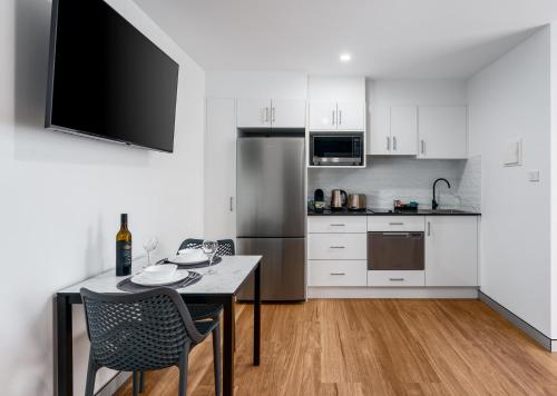 梅特兰Hunter Studios - Maitland的厨房配有桌椅和冰箱。