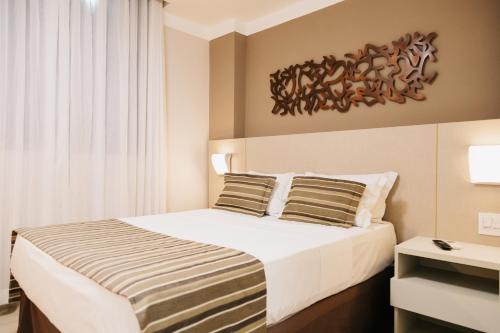 圣湖镇Lagoon Prime Hotel的一间卧室配有一张大床和两个枕头