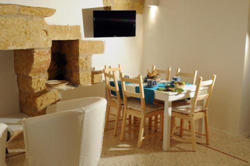 加利亚诺德尔卡波Holiday home La Corte dei Pirri的一间带桌椅和电视的用餐室