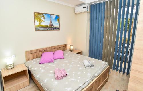 库塔伊西Hotel MASPINDZELO的一间卧室配有一张带两个粉红色枕头的床
