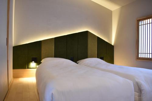 京都TABITABI KANOE MITSU的带窗户的客房内的2张白色床