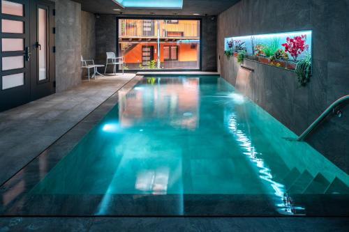 奥洛特Apartaments y Habitacions Entre Volcans的一座蓝色海水室内游泳池,位于一座建筑中