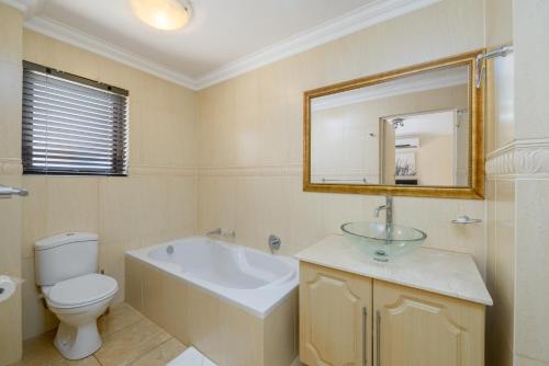 绍斯布鲁姆San Lameer Villa 2812 - 4 Bedroom Classic - 8 pax - San Lameer Rental Agency的带浴缸、盥洗盆和卫生间的浴室