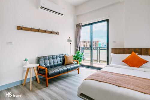 马公Penghu Lemongrass的一间卧室配有一张床、一张沙发和一个窗口