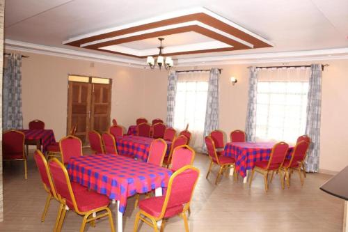 基塔莱Stay.Plus Villa Serene Kitale的一间设有红色和蓝色桌椅的房间