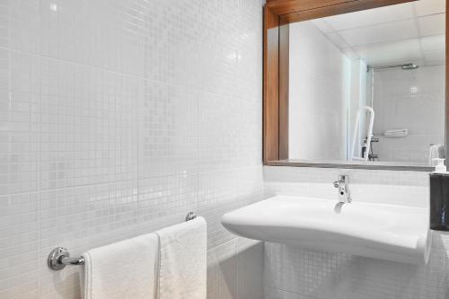 维尼森斯勒博特涅Greet Hotel Versailles - Voisins Le Bretonneux的白色的浴室设有水槽和镜子