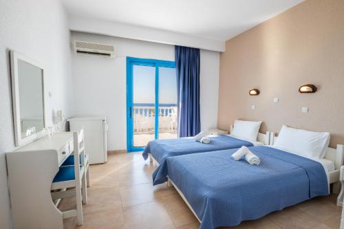 阿莫皮Castelia Bay Hotel的一间卧室设有两张床、一张桌子和一个窗口。