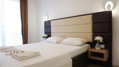 乌尔齐尼Ponte Apartments的一间卧室配有一张带黑白床头板的床