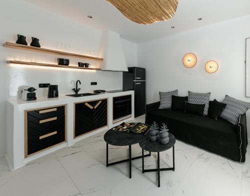 纳克索乔拉Black Concept Maisonette的一间带黑色沙发的客厅和一间厨房