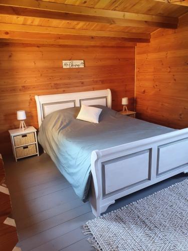 Marigny-lès-ReulléeDOMAINE DES GALLINACES CHALET SUSSEX 2-4p的木制客房内的一间白色床卧室