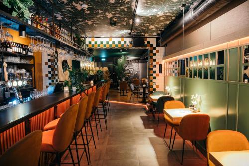 埃因霍温Winston B&B的餐厅设有酒吧,配有橙色椅子和桌子