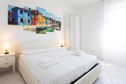 博洛尼亚15 - Tourist House Bologna Primaticcio - Self check-in的卧室配有白色的床和墙上的绘画作品