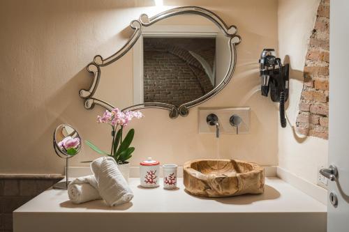 TorpèDomu Manca的浴室水槽内装有镜子和鲜花