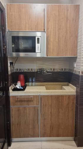 Sīdī Ḩamzahفندق السد الخليجى的一间带木制橱柜和微波炉的厨房