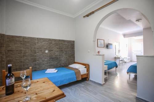 卡马利季米特里斯别墅酒店的一间设有一张床和一张桌子及一瓶葡萄酒的客房