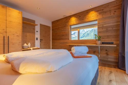圣坎迪朵Chalet Panorama Himmelreichhof的卧室配有一张大白色床和窗户