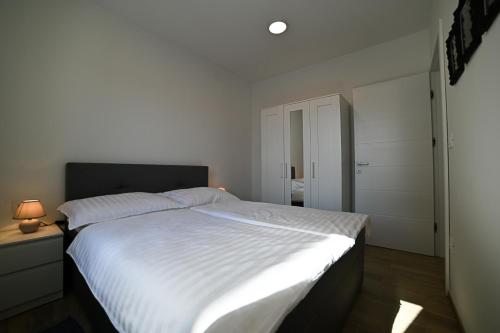 茨雷斯Apartment Perlitto的一间卧室配有一张带白色床单的大床