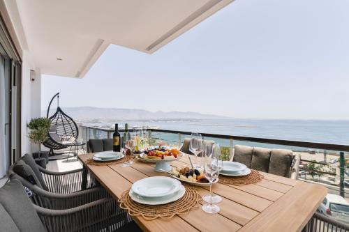 比雷埃夫斯Divine Residence, a SeaView Retreat, By ThinkVilla的阳台上的桌子上摆放着食物和葡萄酒