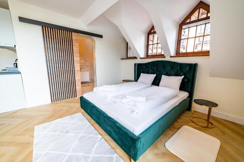米科瓦伊基Apartamenty Mazurskie的一间卧室配有一张大床和绿色床头板