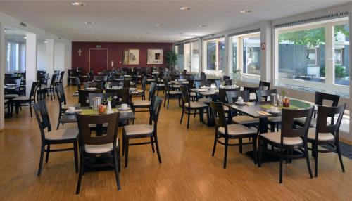 黑措根奥拉赫Nell-Breuning-Hotel的用餐室设有桌椅和窗户。
