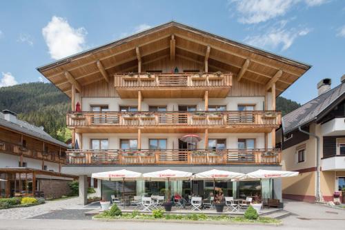 魏森湖Draxl-Hof Ferienwohnungen的酒店设有带桌子和遮阳伞的阳台