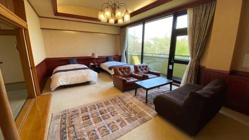 大崎市Tabinoyado Yakurai Rinsenkan的一间卧室配有一张床和一张沙发