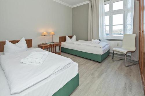 赛巴特班森Seehof Seehof 31的酒店客房,配有两张床和椅子