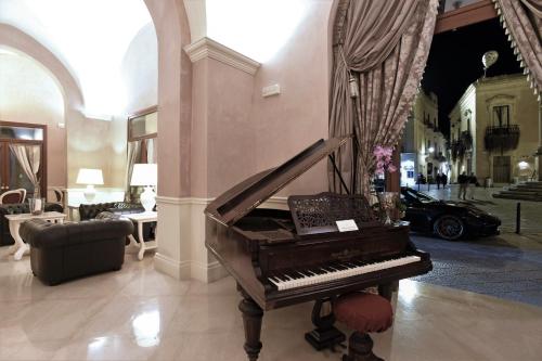 莱切圣基娅拉套房酒店的大堂的钢琴,有车的房间