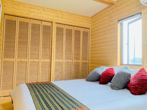 八街BALLAD HOUSE / Vacation STAY 27536的一间卧室配有一张带木墙和窗户的床。