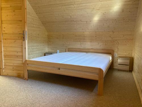 大卡尔洛维采Chalupa Nella II.的木制客房内的一间卧室,配有一张床