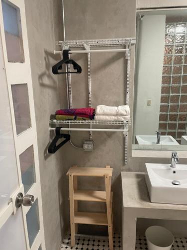 圣胡安The Emerald PR的浴室设有水槽和带毛巾的架子。