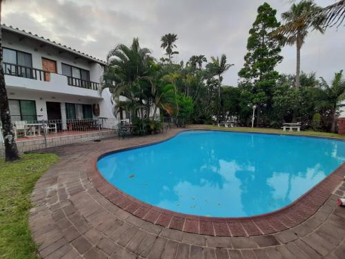 圣卢西亚St Lucia Villa Mia 5的大楼前的大型蓝色游泳池