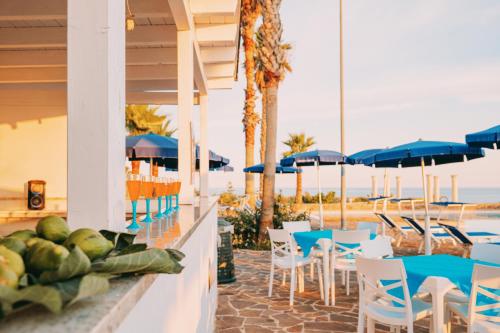 佩斯科勒海滨Picchio Hotel Pescoluse的一间带桌椅的餐厅以及海滩