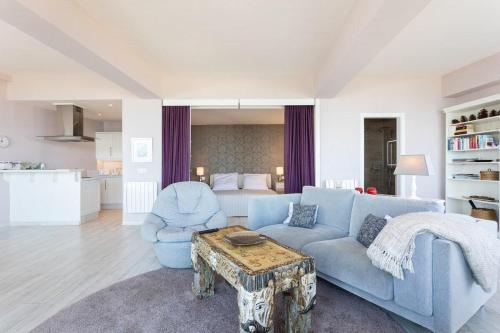 拉克鲁斯Prime Homes Playa Jardin Studio的客厅配有蓝色的沙发和桌子