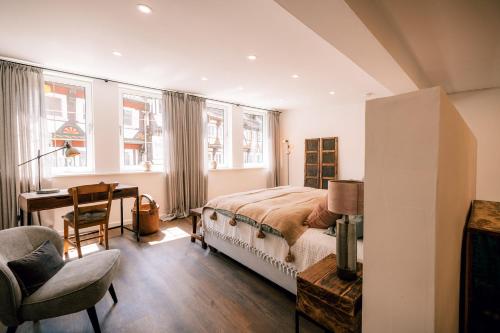 艾恩贝克Wohnung in der Fußgängerzone mit Finca Flair的一间卧室配有一张床、一张书桌和一些窗户。
