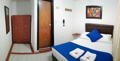 波哥大CASA HOTEL VICTORIA Av 30的卧室配有蓝色和白色的床和木门。